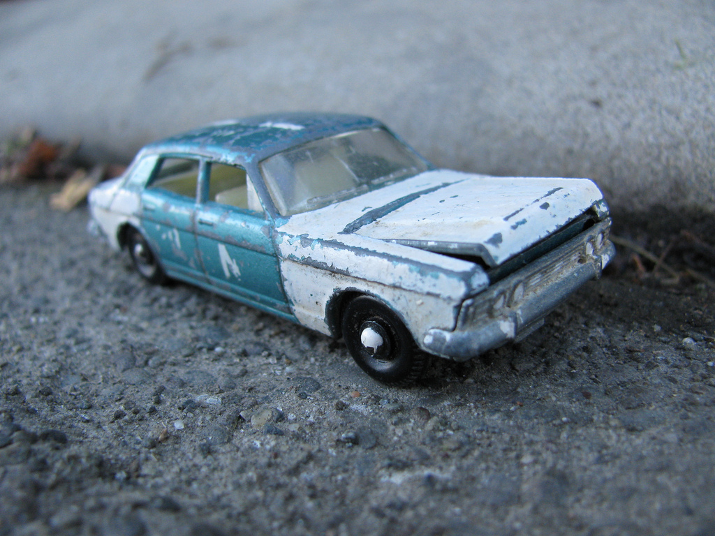 Beaten up and scuffed toy car photographed as if it were a real car